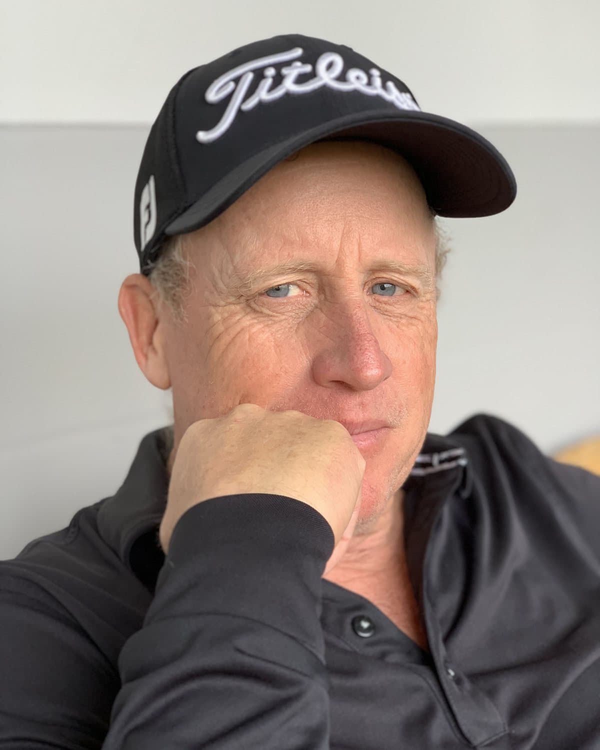 Ted Long, four-time PGA of Germany Teacher of the Year, close-up portrait in a cap and dark polo